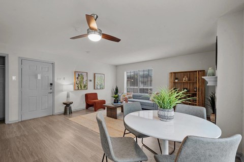 a living room with a round table and a ceiling fan